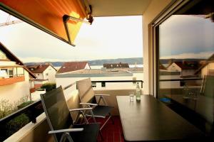 a balcony with a table and chairs and a large window at FeWo Louisa in Sipplingen