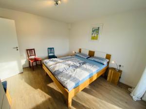 ein Schlafzimmer mit einem Bett und zwei Stühlen darin in der Unterkunft Apartment Relax in Überlingen Bodensee in Überlingen