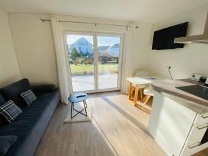a living room with a couch and a kitchen with a window at Apartment Relax in Überlingen Bodensee in Überlingen