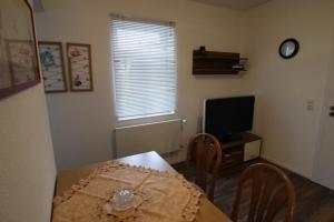 a dining room with a table and a television at NEU! FeWo Winkeleck in Alsfeld