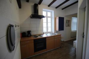 a kitchen with a stove and a sink and a refrigerator at NEU! FeWo Winkeleck in Alsfeld