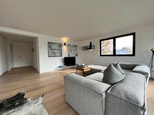a living room with a couch and a television at seenahe Design-Ferienwohnung Loft Azur in Überlingen