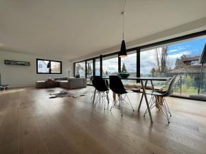 a living room with a dining table and chairs at seenahe Design-Ferienwohnung Loft Azur in Überlingen