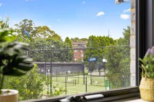 a window with a view of a baseball field at Lovely Studio apartments in Strathfield CBD in Sydney