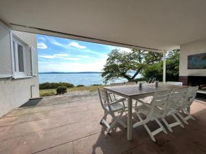 einen Tisch und Stühle auf einer Terrasse mit Meerblick in der Unterkunft Landhaus am See mit privatem Seezugang in Meersburg