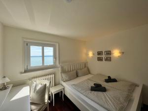ein kleines Schlafzimmer mit einem Bett und einem Fenster in der Unterkunft Landhaus am See mit privatem Seezugang in Meersburg