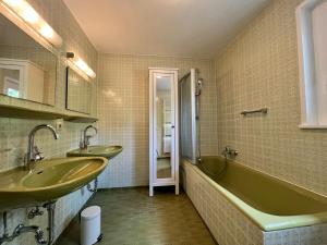 uma casa de banho com 2 lavatórios e uma banheira em Landhaus am See mit privatem Seezugang em Meersburg