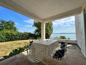 un patio con tavolo, sedie e vista sull'oceano di Landhaus am See mit privatem Seezugang a Meersburg