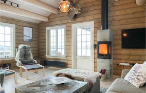 Cabaña de madera con sala de estar con chimenea en Beautiful Home In Bjorli With Wifi, en Bjorli