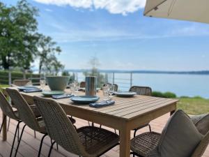 einen Holztisch mit Stühlen auf einer Terrasse in der Unterkunft Villa am See mit privatem Seezugang in Meersburg