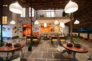 een restaurant met tafels en stoelen en hanglampen bij Boheme in Morjim