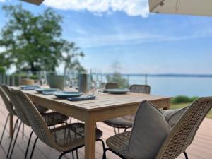 einen Holztisch und Stühle auf einer Terrasse in der Unterkunft Villa am See mit privatem Seezugang in Meersburg