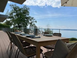 einen langen Holztisch mit Stühlen auf einer Terrasse in der Unterkunft Villa am See mit privatem Seezugang in Meersburg