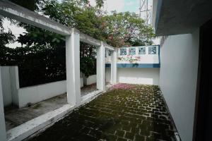 an empty walkway in a white building with trees at Genga Nilayam Homestay in Virudunagar