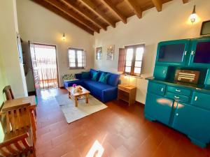 Una sala de estar con un sofá azul y una mesa. en Da Silva Surfcamp- Terrassenzimmer mit Frühstück, en Lourinhã