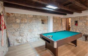 a pool table in a room with a stone wall at Gorgeous Home In Neoric With Kitchen in Neorić
