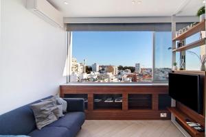 - un salon avec un canapé bleu et une grande fenêtre dans l'établissement Casa Alameda, à Faro