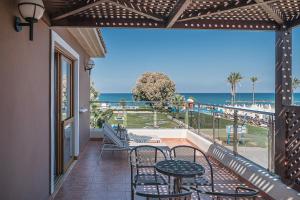 a balcony with a table and chairs and the ocean at Caldera Creta Paradise in Platanias