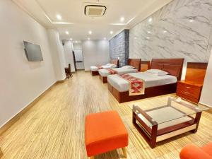 een hotelkamer met drie bedden en een tafel bij Long Bao Chau Hotel in Thu Dau Mot