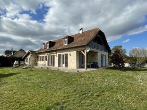 a large house with a grass field in front of it at Chez evelyne et titou in Bordères