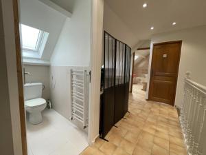 a bathroom with a toilet and a hallway with a window at Chez evelyne et titou in Bordères +13 photos