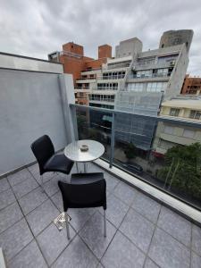 un balcone con tavolo e sedie e un edificio di HERMOSO - CONFORT con Balcón en Gral Paz a Córdoba