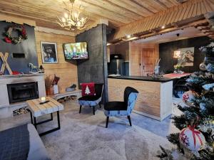 uma sala de estar com uma árvore de Natal e uma cozinha em Domek do wynajęcia "Jodłowe Izby" em Białka Tatrzanska