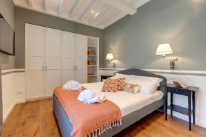 Un dormitorio con una cama y una mesa con toallas. en Mamo Florence - La Badessa Apartment, en Florencia