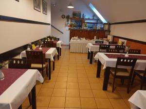 a dining room with white tables and chairs and a table at Penzion Raj in Rajecké Teplice