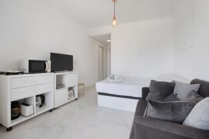 a white living room with a bed and a couch at Calle Manuel Mena 4 in Benalmádena