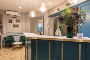 um átrio com um bar com um vaso de flores em Hotel Splendid em Paris