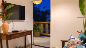 a living room with a television and a table with a mirror at Residencial Villa I in Trancoso