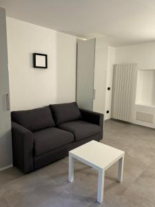 un soggiorno con divano nero e tavolino bianco di Ca' Buscion a Stresa