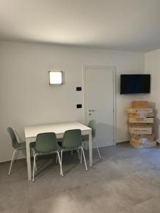 una camera con tavolo, sedie e televisore di Ca' Buscion a Stresa