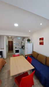 a living room with a blue couch and a wooden table at Center Studio 3pax apartamento in Trelew