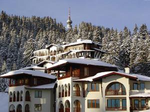 a large building with snow on top of it at Apartment Snezhanka in Pamporovo
