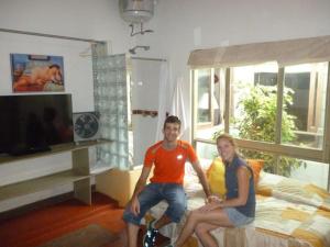 duas pessoas sentadas numa cama num quarto em Hospedaje Punta Hermosa em Punta Hermosa