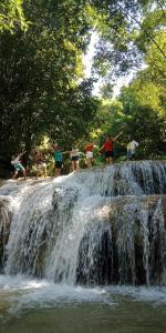 un grupo de personas de pie en la cima de una cascada en Pù luông homestay Ngọc Dậu, en Thanh Hóa