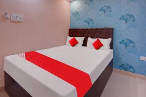 a bedroom with a bed with red and white pillows at Super OYO Flagship Hotel Relax Rainbow in Gulzārbāgh