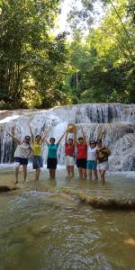 a group of women standing in front of a waterfall at Pù luông homestay Ngọc Dậu in Thanh Hóa