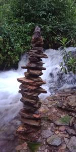 ein Felsstapel in einem Bach mit Wasserfall in der Unterkunft Pù luông homestay Ngọc Dậu in Thanh Hóa