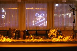 マドンナ・ディ・カンピリオにあるStyle Hotel Grifoneの窓際にクリスマスツリーのある部屋のソファ