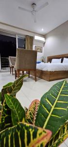 a bedroom with a bed and a plant in the foreground at Mallenzo suites in Gurgaon