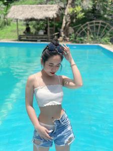 a young woman standing in a swimming pool at Pù luông homestay Ngọc Dậu in Thanh Hóa