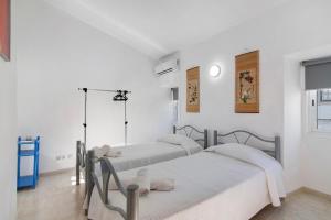 zwei Betten in einem Zimmer mit weißen Wänden in der Unterkunft Casa da Vila nº4 in São Brás de Alportel