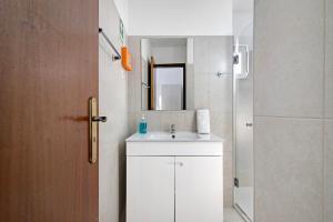 ein Badezimmer mit Waschbecken und Spiegel in der Unterkunft Casa da Vila nº4 in São Brás de Alportel