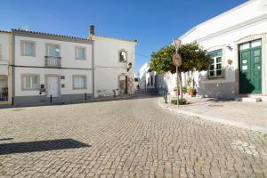 eine Kopfsteinpflasterstraße in einer Stadt mit weißen Gebäuden in der Unterkunft Casa da Vila nº4 in São Brás de Alportel