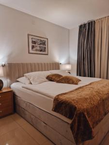 a bedroom with a large bed with brown blankets at Aparthotel Gaja in Bled