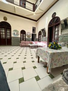 Cette chambre comprend une table avec des fleurs. dans l'établissement HÔTEL DU PARC, à Fès