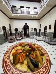 une assiette de nourriture sur une table dans une pièce dans l'établissement HÔTEL DU PARC, à Fès